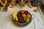 Decorative tray with mosaic design and gold trim on a textured white background